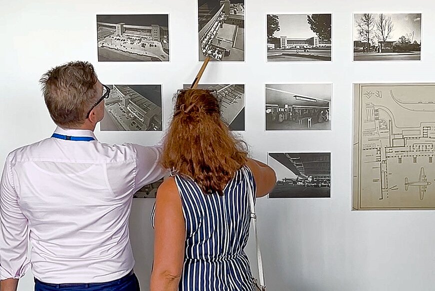 Menschen betrachten Bauzeichnungen.