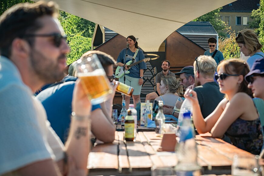 Menschen sitzen im Biergarten.