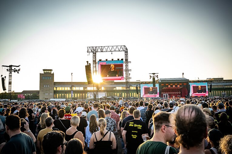 Eine Menschenmenge auf dem Vorfeld. Im Hintergrund ist die Bühne zu sehen.
